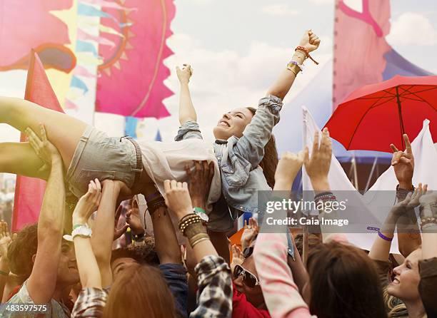 woman crowd surfing at music festival - crowd surfing stock pictures, royalty-free photos & images