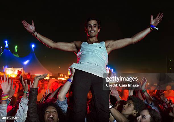 portrait of confident performer with fans cheering in background - crowd surfing stock pictures, royalty-free photos & images