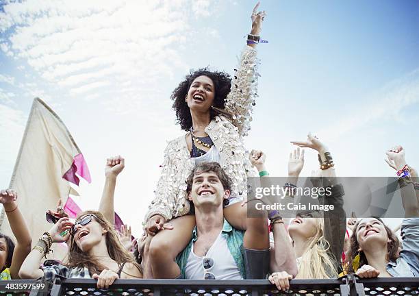 aclamar mujer en manês hombros en music festival - llevar al hombro fotografías e imágenes de stock