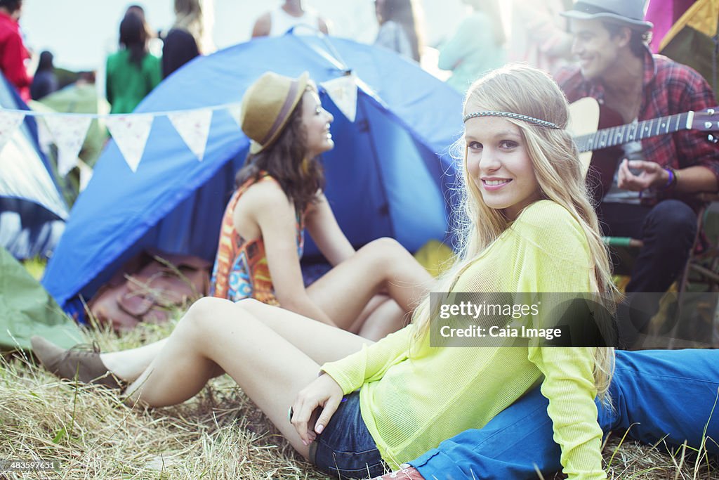 Portrait of woman hanging out with friends outside tent at music festival