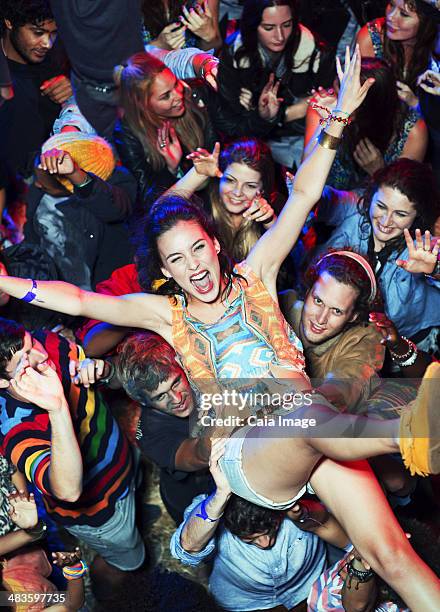 enthusiastic woman crowd surfing at music festival - crowdsurfing stockfoto's en -beelden