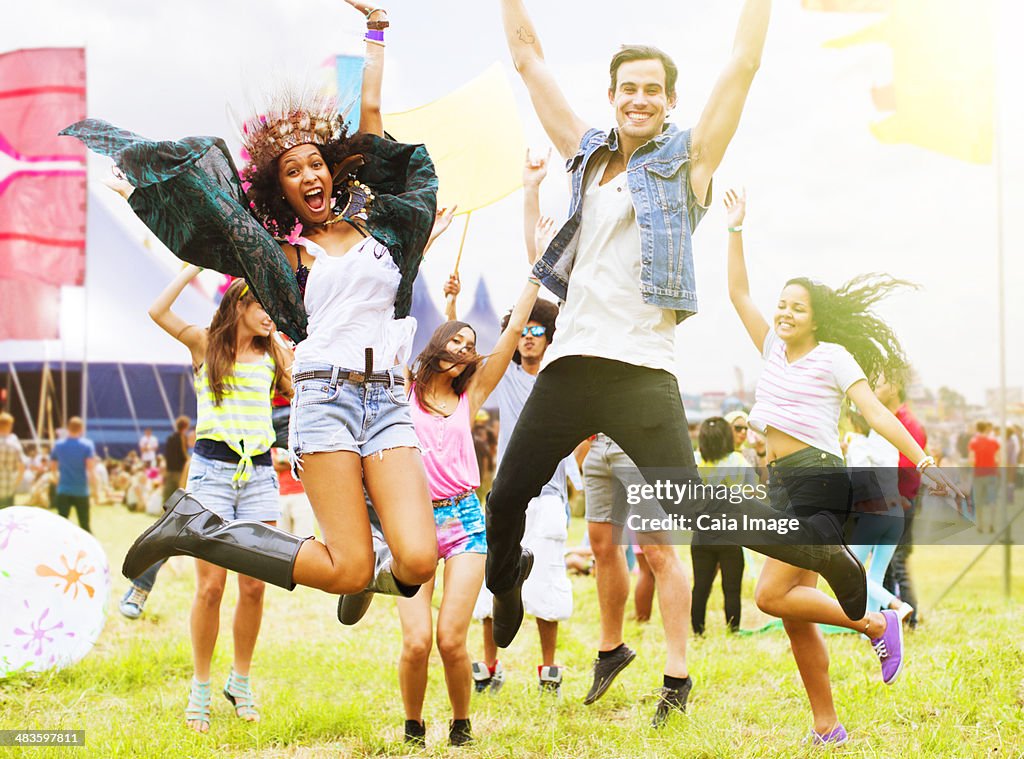 Portrait of enthusiastic friends jumping and dancing at music festival