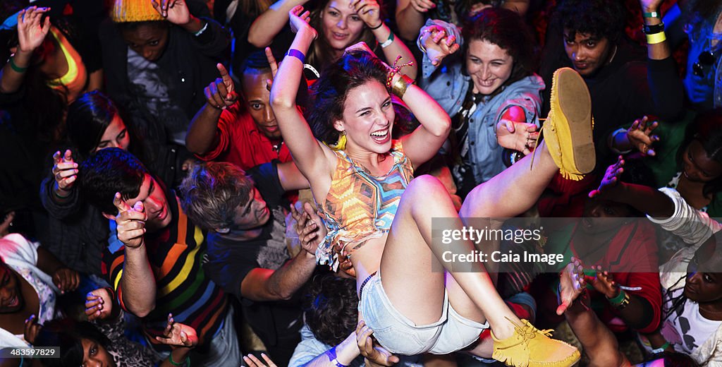 Enthusiastic woman crowd surfing at music festival