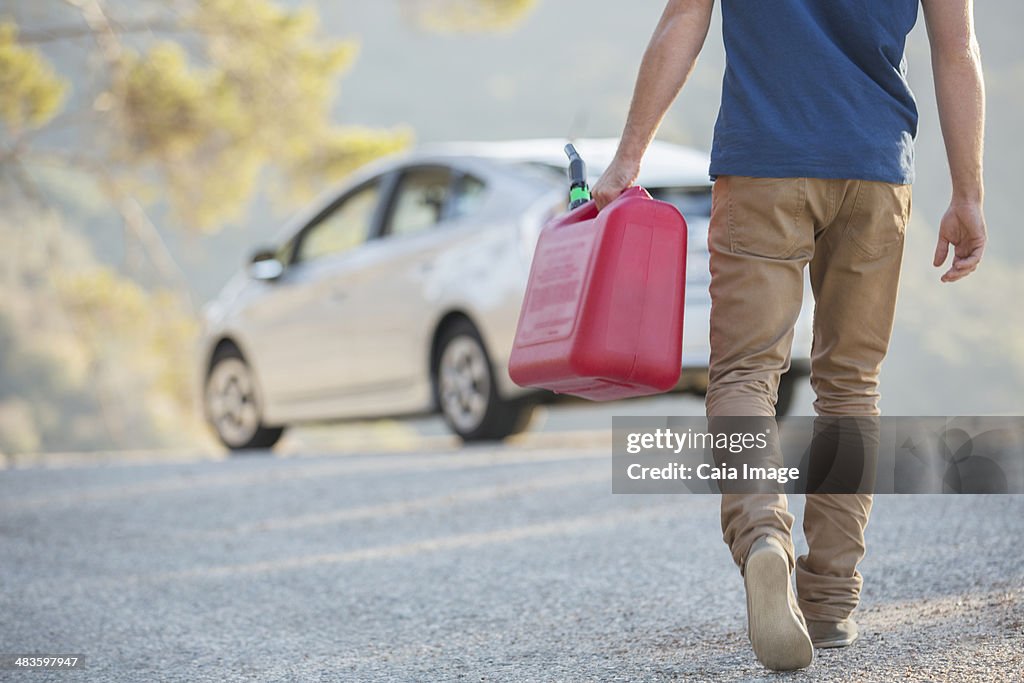 Mann tragen Benzinkanister zum Auto am Straßenrand