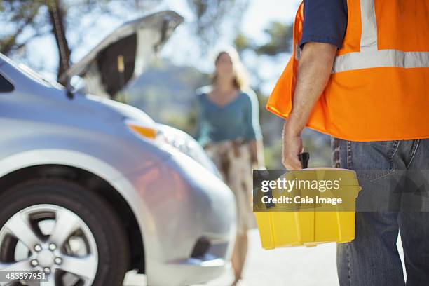 roadside mechanic with toolbox arriving to help woman - car toolbox stock pictures, royalty-free photos & images