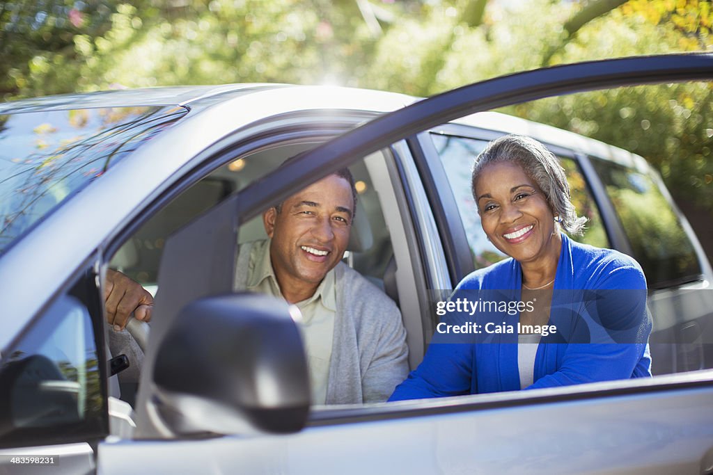 Retrato de pareja feliz en el interior y exterior de coche