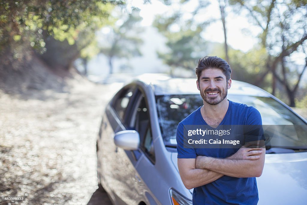 Portrait of smiling man leaning on car