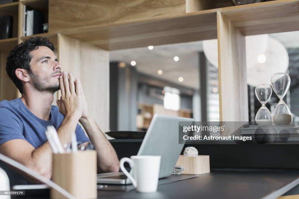 Pensive man at laptop in home office