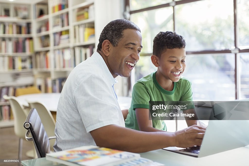 Grandfather and grandson using laptop