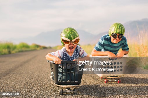 Jovens rapazes corridas usando capacetes de melancia Jovens rapazes corridas usando capacetes de melancia