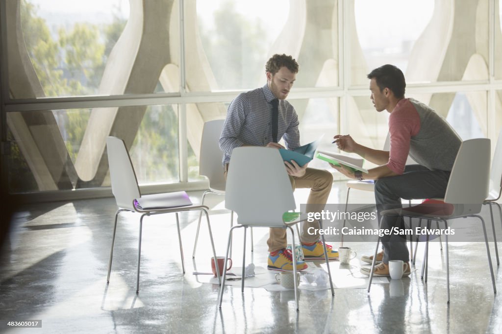 Creative businessmen brainstorming in circle of chairs