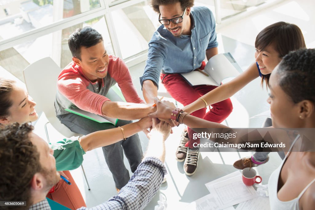 Des hommes d'affaires les mains dans un huddle communicantes