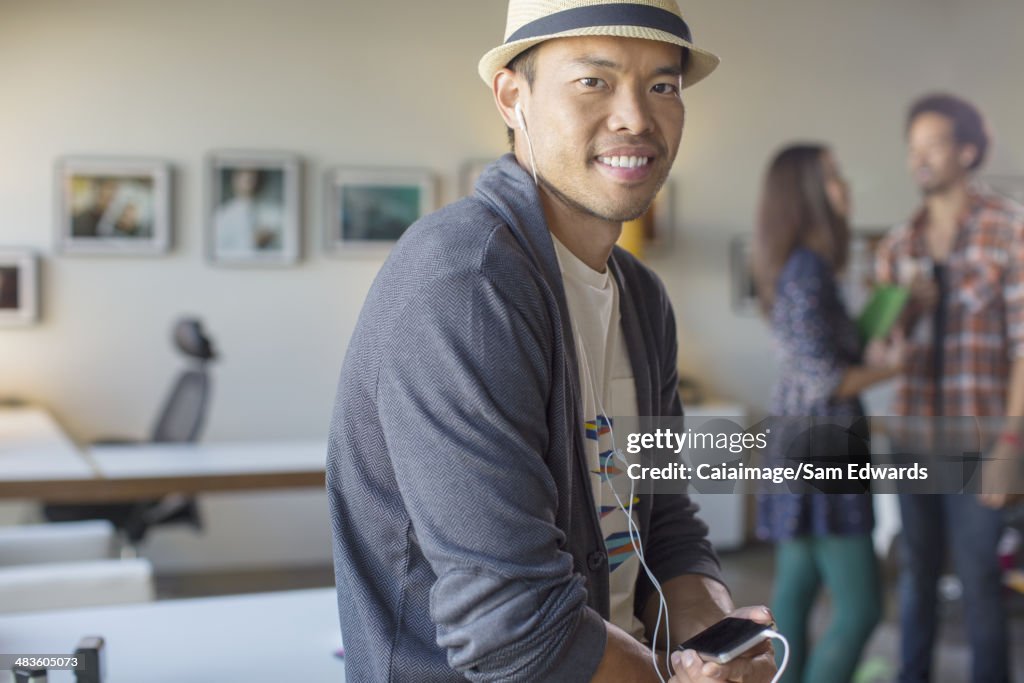 Portrait of casual businessman listening to music with mp3 player and headphones