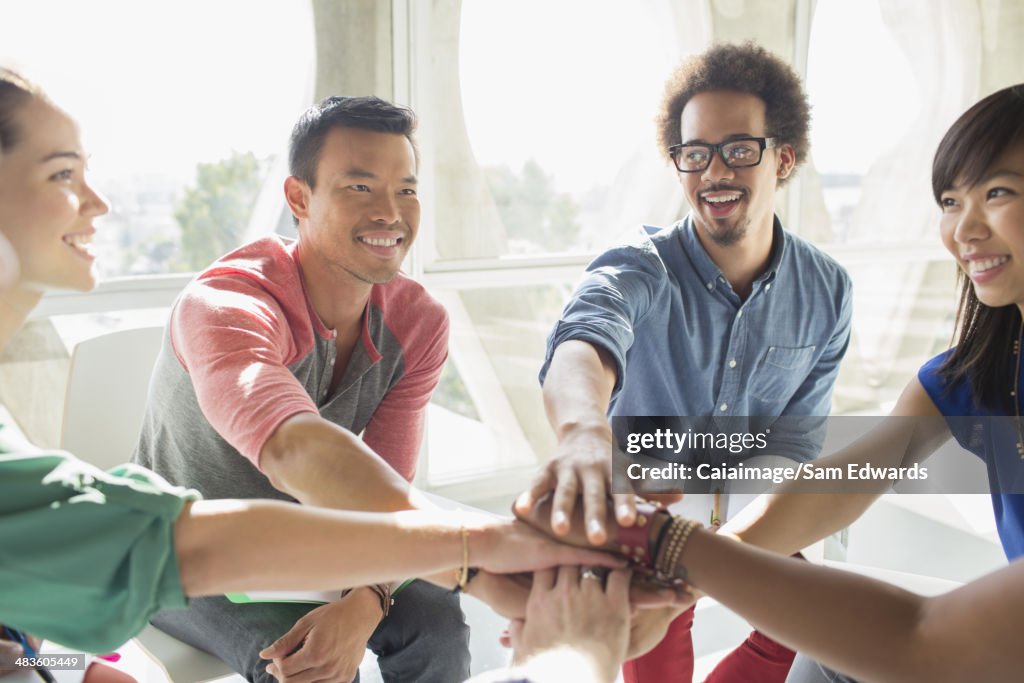 Creative business people connecting hands in huddle