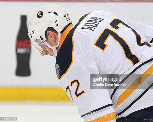 Luke Adam of the Buffalo Sabres skates off the ice after getting hit in the mouth with a puck during an NHL game against the Detroit Red Wings on...