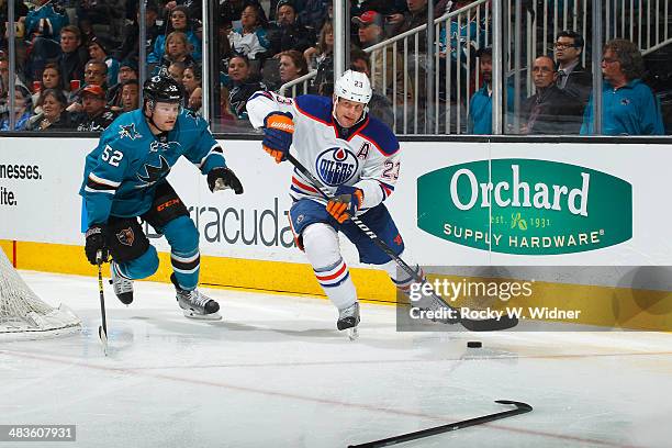 Matt Hendricks of the Edmonton Oilers skates with the puck against Matt Irwin of the San Jose Sharks at SAP Center on April 1, 2014 in San Jose,...