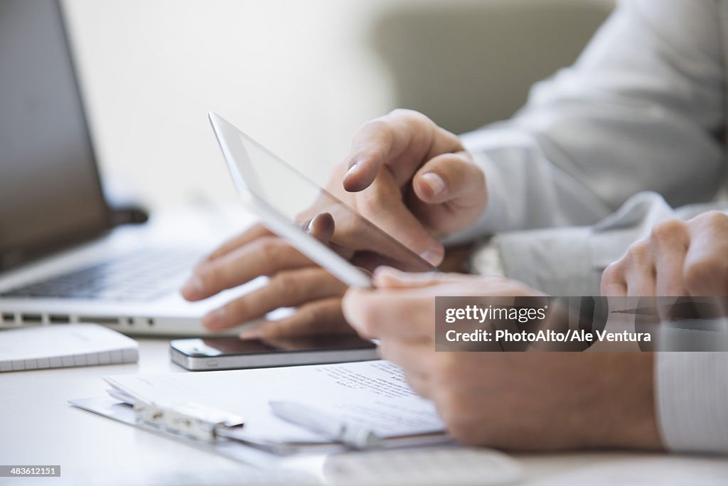 Men using digital tablet, cropped