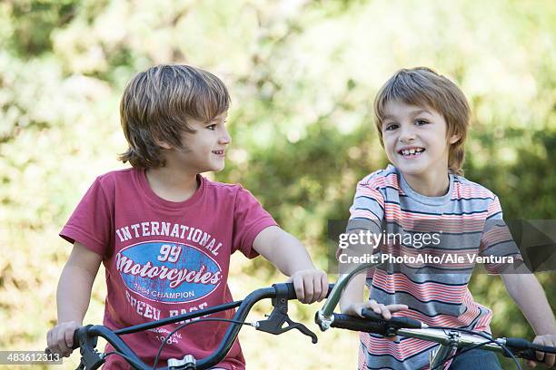 boys riding bicycles side by side - two kids with cycle stock-fotos und bilder