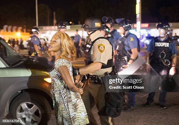 Demonstrator is arrested during a protest marking the one-year anniversary of the shooting of Michael Brown along West Florrisant Street on August...