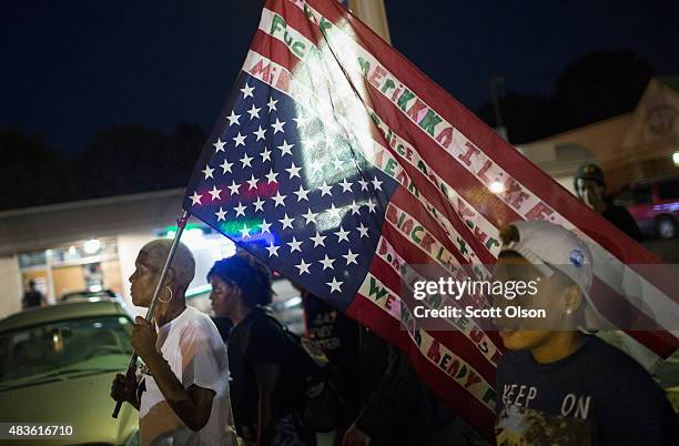 Demonstrators, marking the one-year anniversary of the shooting of Michael Brown, protest along West Florrisant Street on August 10, 2015 in...