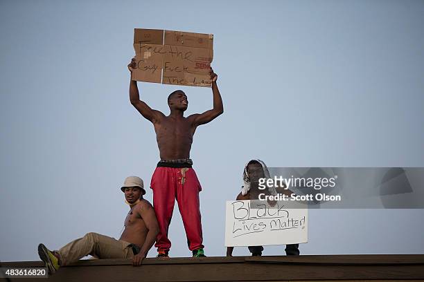 Demonstrators, marking the one-year anniversary of the shooting of Michael Brown, protest along West Florrisant Street on August 10, 2015 in...