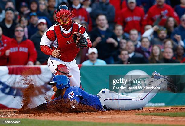 Evlis Andrus of the Texas Rangers slides safely into home plate to score in the 8th inning past A.J. Pierzynski of the Boston Red Sox at Fenway Park...