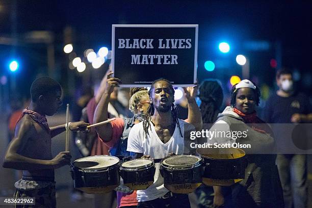 Demonstrators, marking the one-year anniversary of the shooting of Michael Brown, protest along West Florrisant Street on August 10, 2015 in...