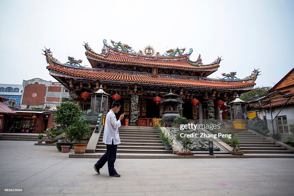 A young Taoist walks in front of Sanqing Palace, the main...