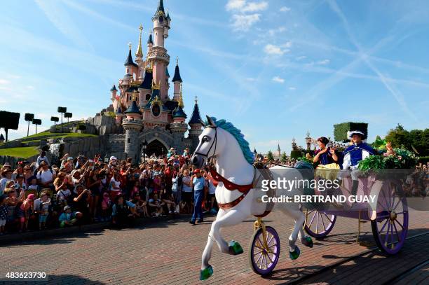Crowds watch as Snow White and her prince ride past on a carriage during the Main Street Parade at Disneyland Paris, in Marne-la-Vallee, on August 6,...