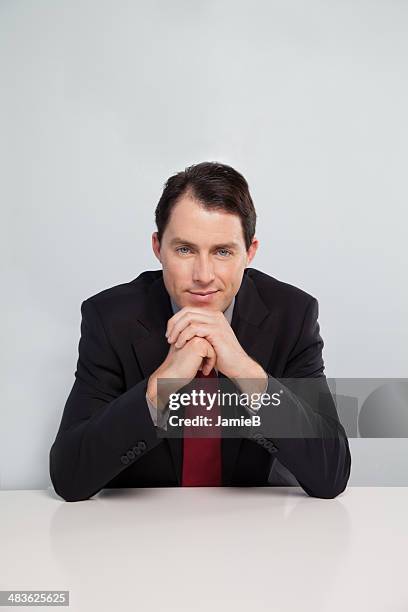 portrait of businessman sitting at table - man hand on chin stock pictures, royalty-free photos & images