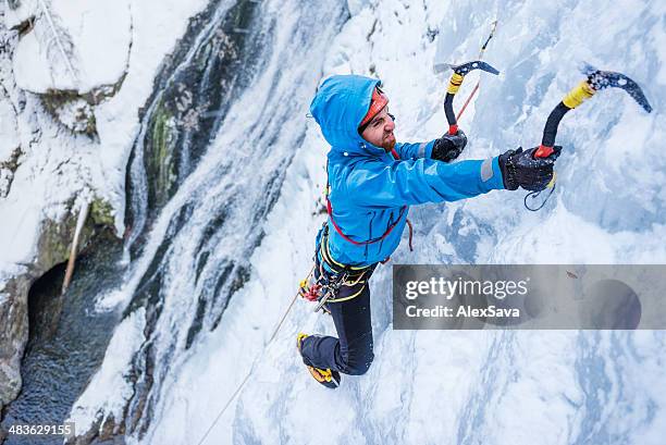 un hombre adulto de escalada sobre hielo congelado cascade - montañismo fotografías e imágenes de stock