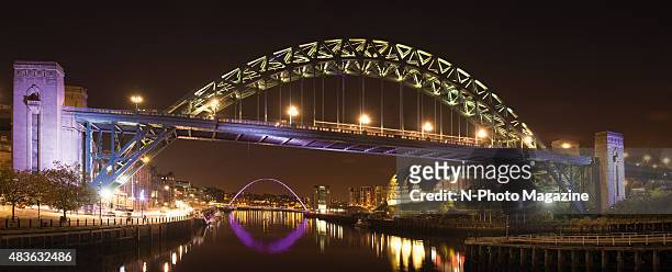 The Tyne Bridge over the River Tyne illuminated at night, with the Gateshead Millennium Bridge visible in the background, taken on October 18, 2014.