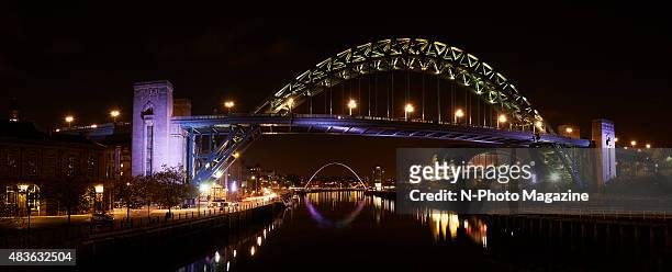 The Tyne Bridge over the River Tyne illuminated at night, with the Gateshead Millennium Bridge visible in the background, taken on October 18, 2014.