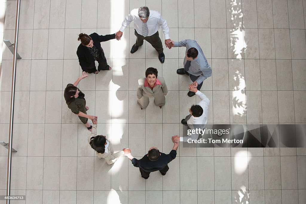 Businesswoman looking up with surrounded by circle of business people