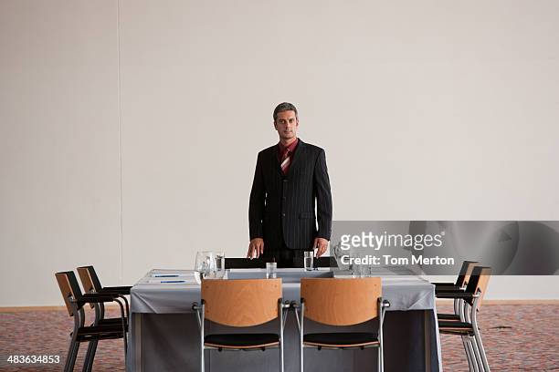 businessman standing in meeting room at table - various angles stock pictures, royalty-free photos & images