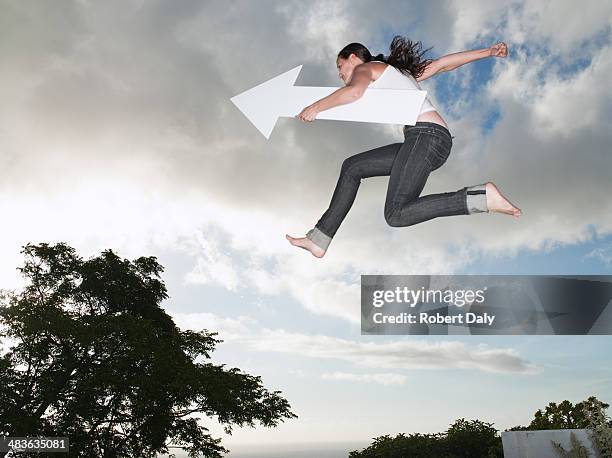 woman with blank arrow leaping outdoors - leap forward stock pictures, royalty-free photos & images