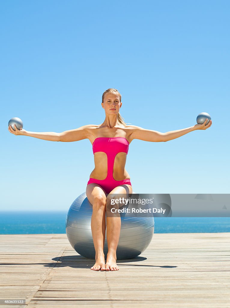 Woman working out with three exercise balls