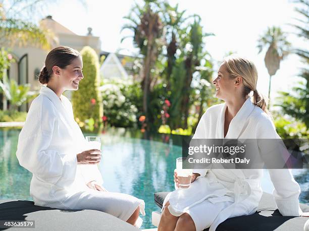 two women relaxing in bathrobes by a pool - health farm 個照片及圖片檔