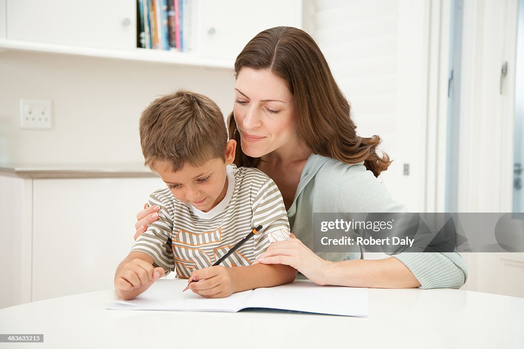 Uma mãe ajudando o seu filho com o seu trabalho de casa