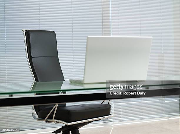empty office chair with laptop on desk - office chair stockfoto's en -beelden