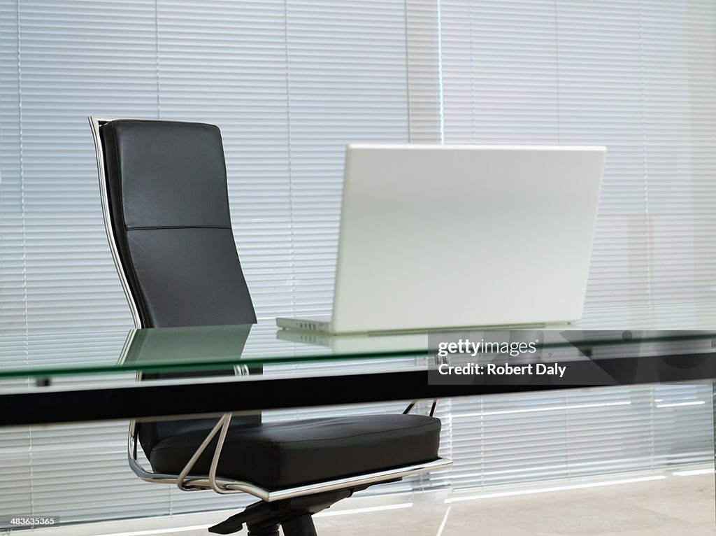 Empty office chair with laptop on desk