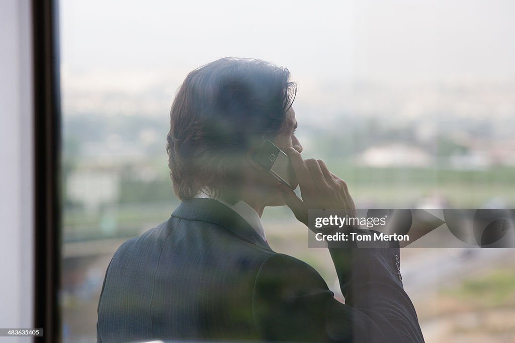 Empresário falando no telefone celular na Varanda