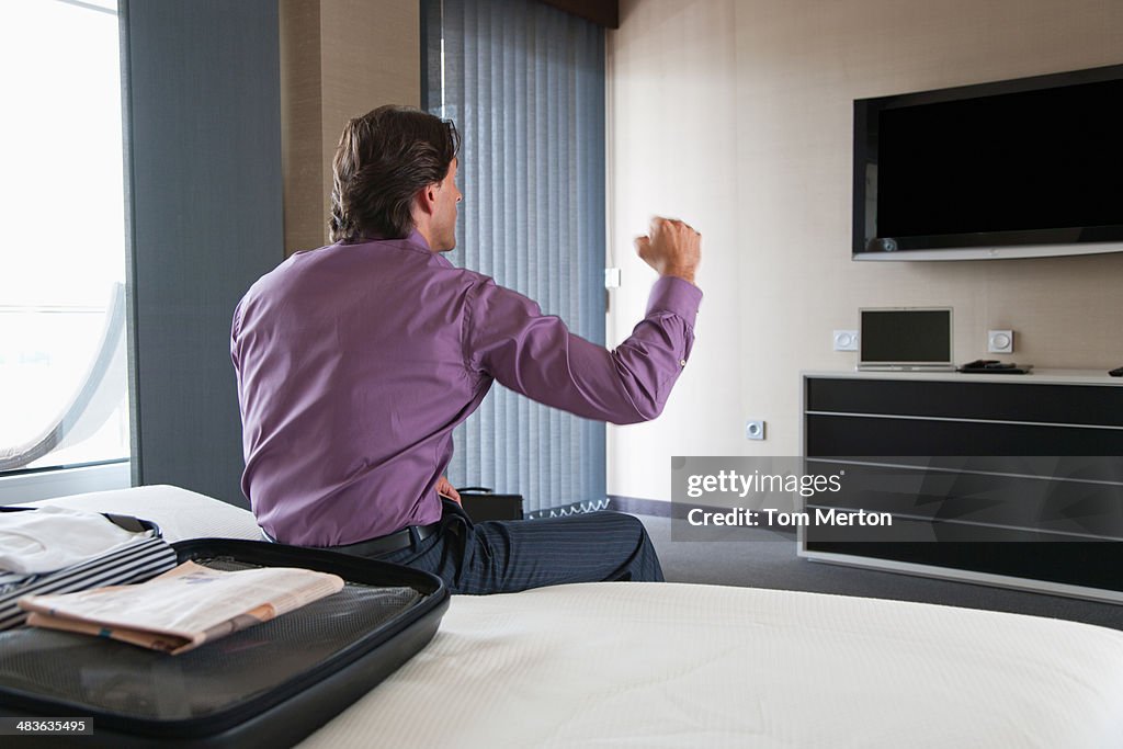 Geschäftsmann vor dem Fernseher im Hotelzimmer