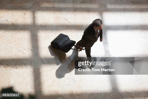 Businessman pulling rolling suitcase Businessman pulling rolling suitcase