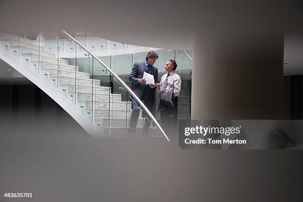 businessmen talking on staircase - offbeat documentation stock pictures, royalty-free photos & images