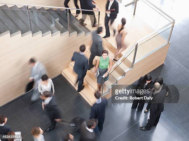 businesspeople walking in busy office building - office motion stock pictures, royalty-free photos & images