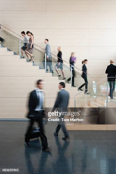 businesspeople walking on busy office staircase - stairs business stockfoto's en -beelden