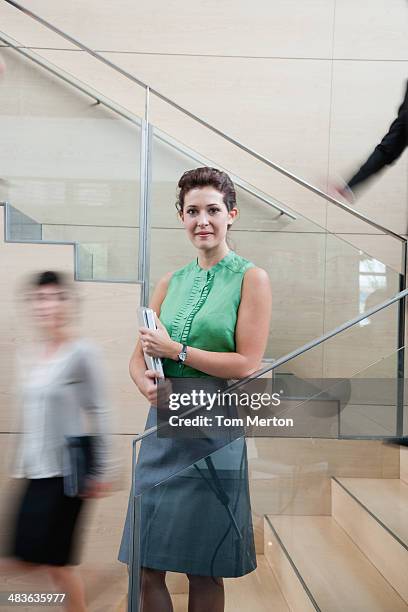 calm businesswoman in staircase - portrait of young woman standing against steps stock pictures, royalty-free photos & images