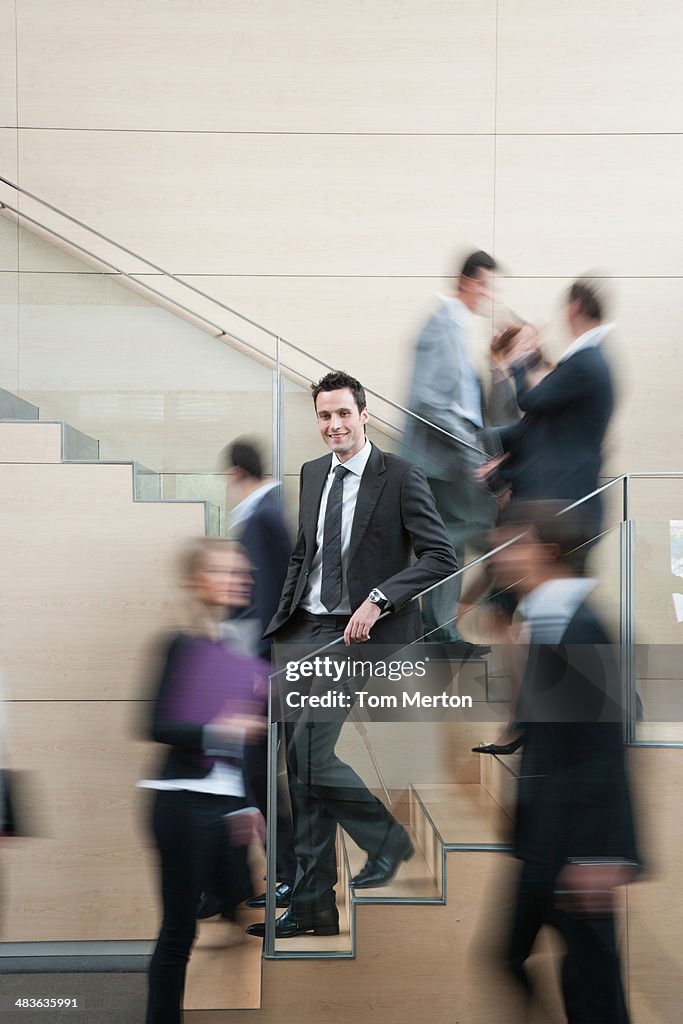 Calm businessman in busy office staircase