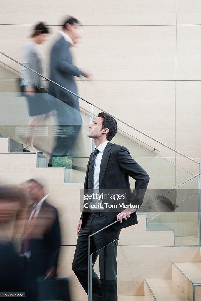 Calm businessman in busy office staircase